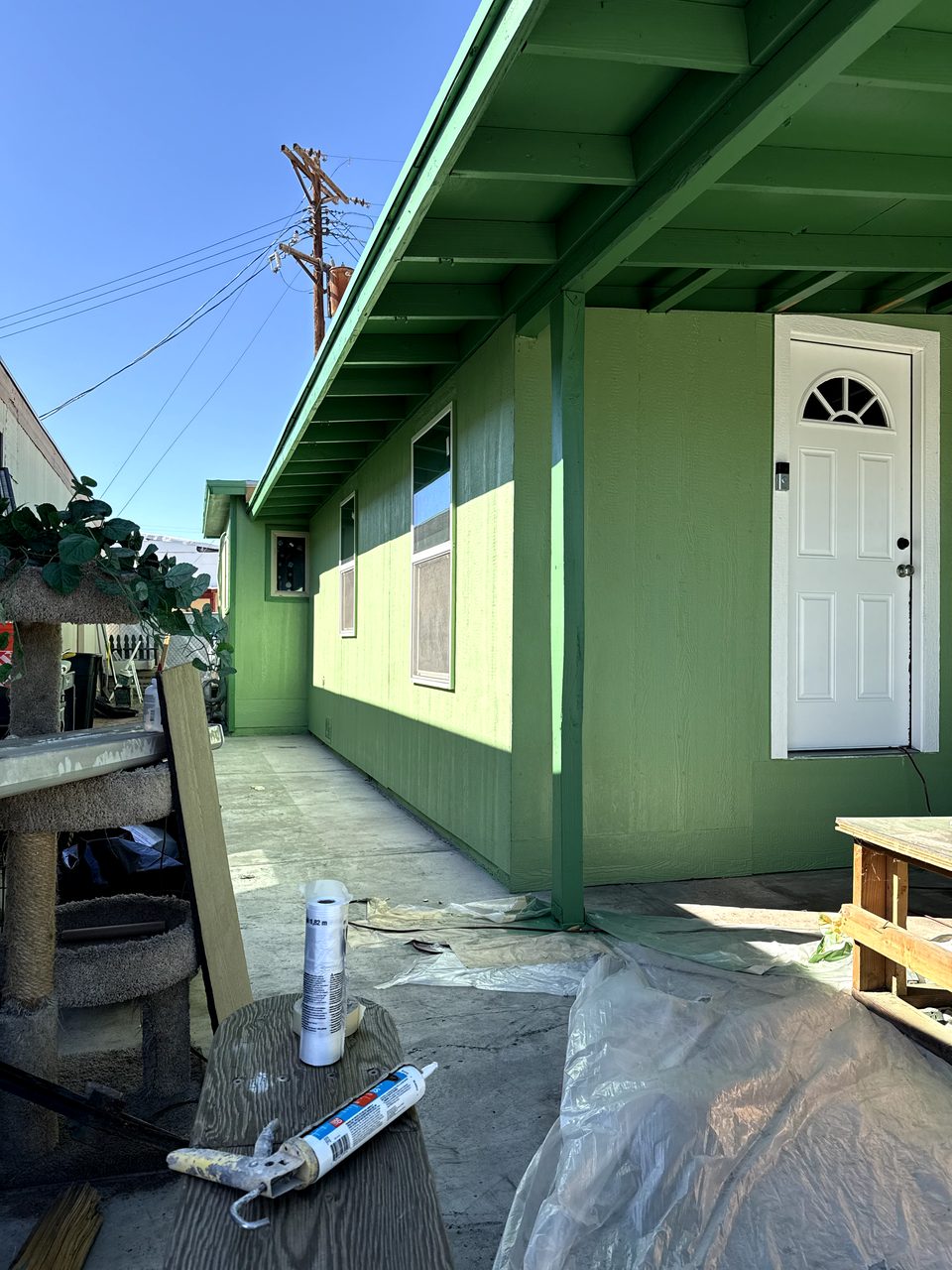 The same Phoenix mobile home after, in a fresh three-tone green metal-siding repaint