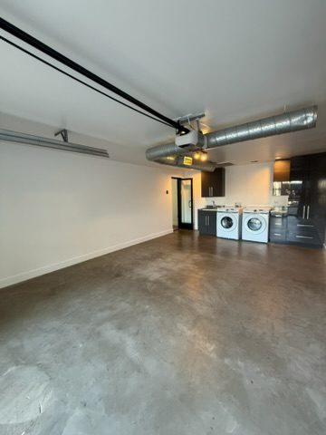 The same kitchenette finished, with smooth white walls and clean exposed ductwork